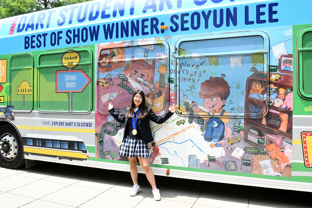 DART Student Art Contest Best of Show Winner, Seoyun Lee, standing in front of wrapped bus