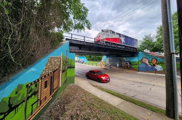 Heritage Mural, red car and Trinity Railway Express over bridge